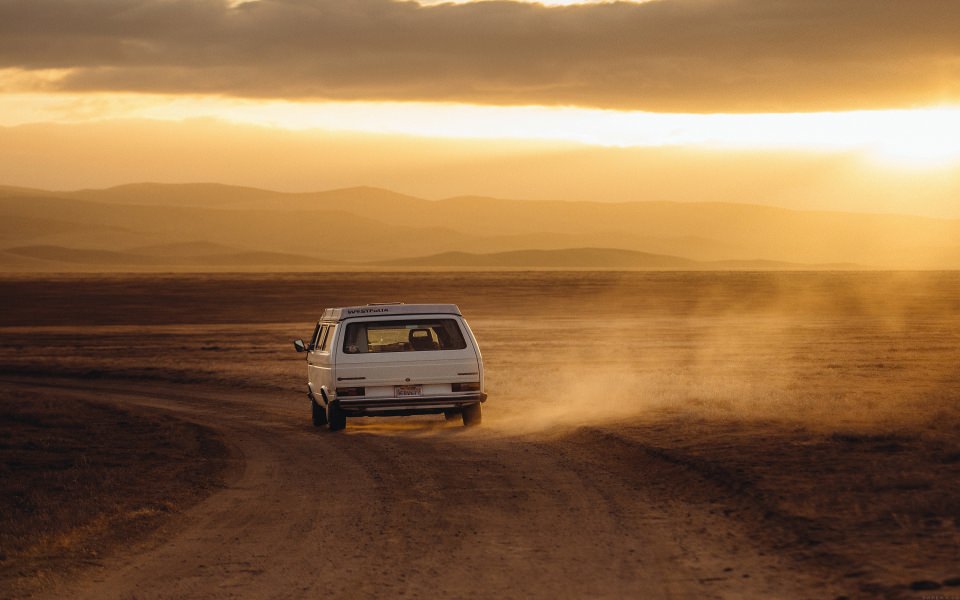 Download White Car Travelling Across Desert wallpaper